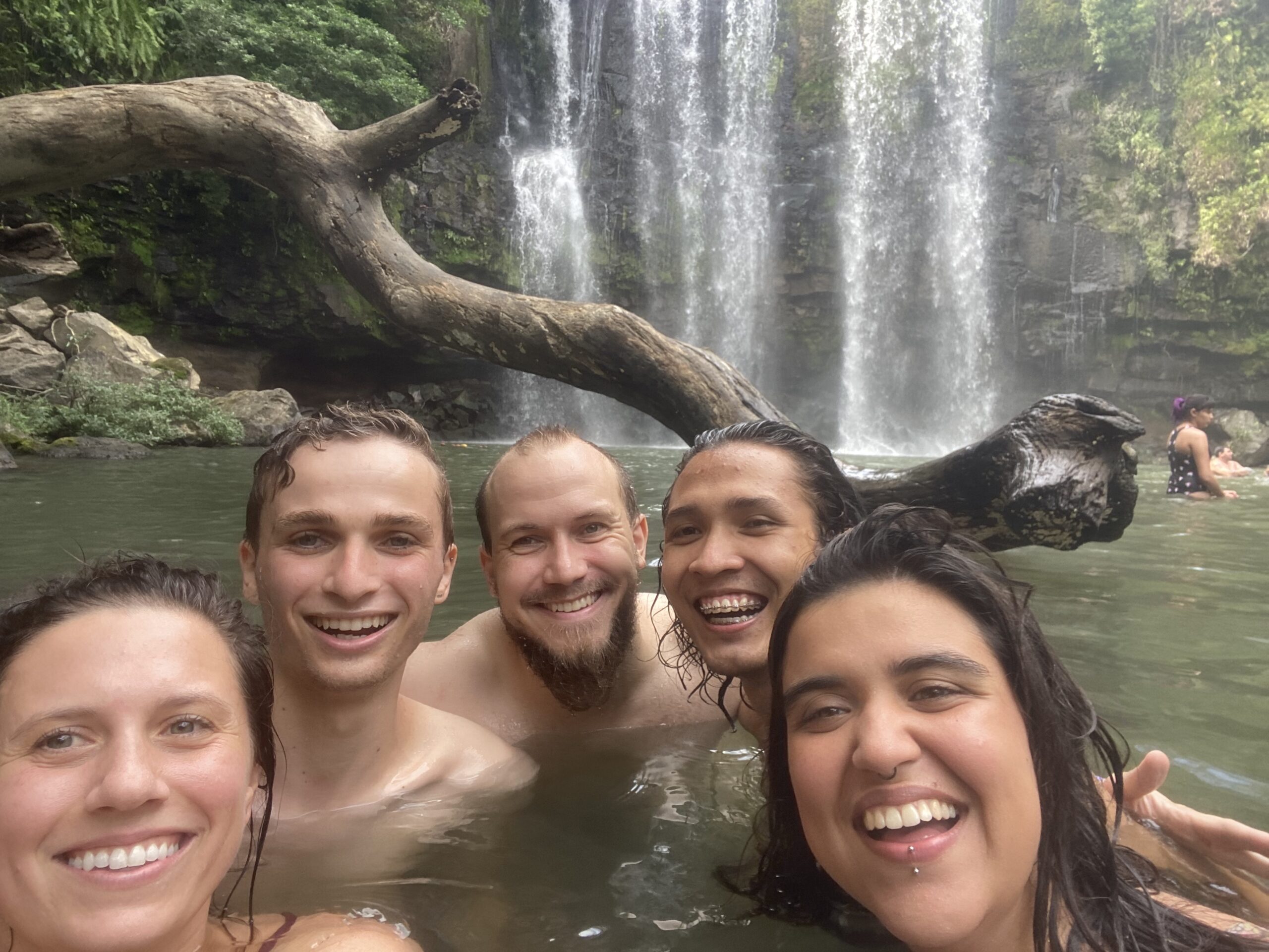 Photo of the team swimming by a waterfall
